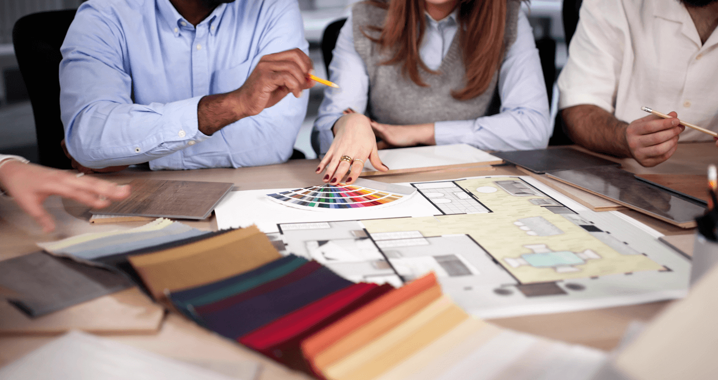 A Group of People Looking at Blueprints and Colour Swatches for Interior Design.