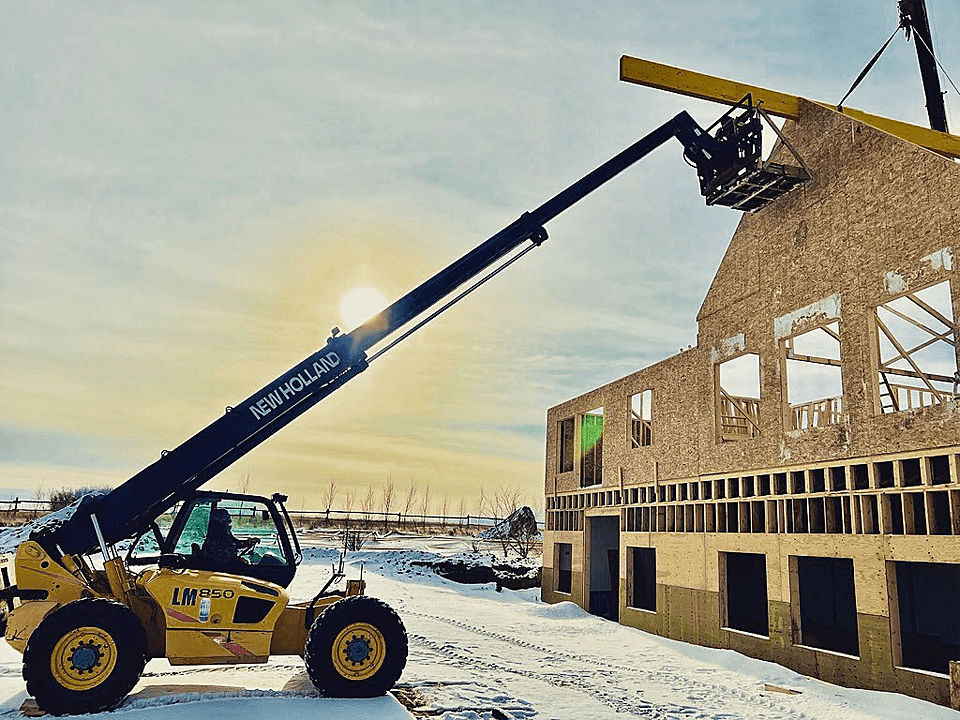 Picture of a Crane Lifting a Framed Section Onto a Building
